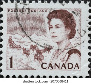 CANADA - CIRCA 1967: A Postage Stamp From Canada Showing A Portrait Of Queen Elizabeth II, Northern Lights And Dog Sled Team