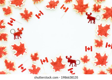 Canada Day Border Including Mini Canada Flags, Moose Key Chains And Canada Flag Sugar Cookies.