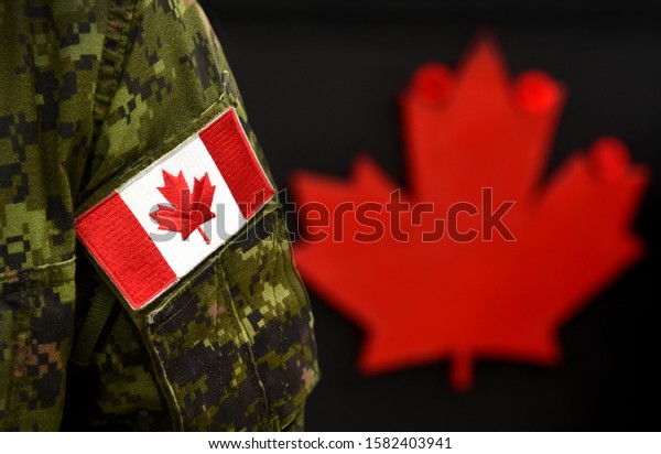 Canada Day. Flag of Canada\
on the military uniform and red Maple leaf on the background.\
Canadian soldiers. Army of Canada. Canada leaf. Remembrance Day.\
Poppy day. 