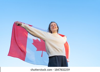 Canada Day. The National Symbol Of The Country. Canadian Flag Waving In Woman's Hands