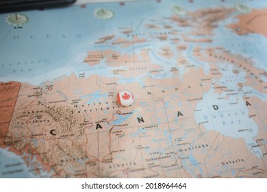 Canada flag drawing pin on the map