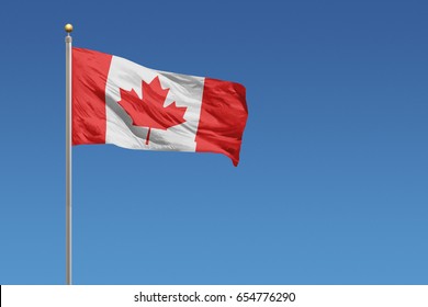 Canada Flag In Front Of A Clear Blue Sky