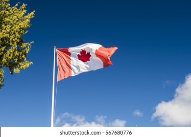 Canada Flag On Clear Blue Sky