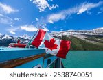 Canada flag on Maligne Lake Cruise. Canadian Rockies Jasper National Park summer scenery. Alberta, Canada.