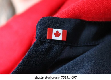 Canada Flag Pin Worn On Navy Blue Collar Of Woman With Red Scarf