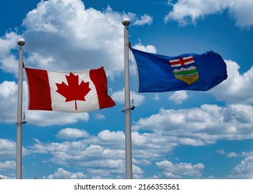 A Canada Flag And A Province Of Alberta Flag On A Blue Sky With Some Clouds