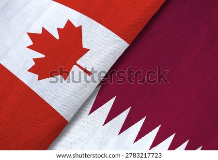 Canada and Qatar flags overlapping, close-up fabric texture, symbolizing diplomacy, sportsmanship, and international bilateral relations.