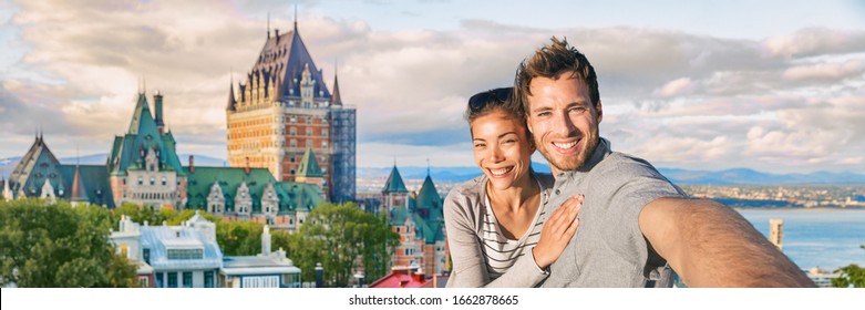 Canada summer travel tourists couple taking selfie photo at famous Quebec city landmark panoramic banner landscape. Happy young people at Frontenac Chateau, Old Quebec.