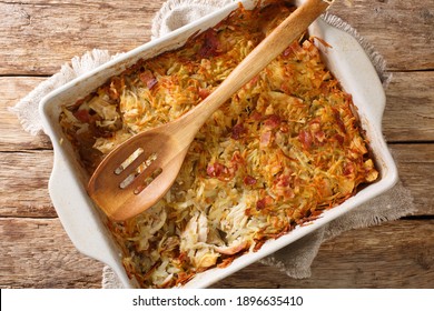 Canadian Rappie Pie, an Acadian classic comfort food dish made with grated potatoes and chicken closeup in a baking dish on the table. Horizontal top view from above