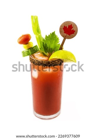 Canadian Caesar drink, typical Canadian drink, with hot sauce, celery, lemon, vodka and ice. Plate with Canadian flag decorating