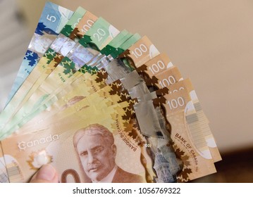 Canadian Dollars, concept of business and finance. Canadian banknotes of different values in hand.