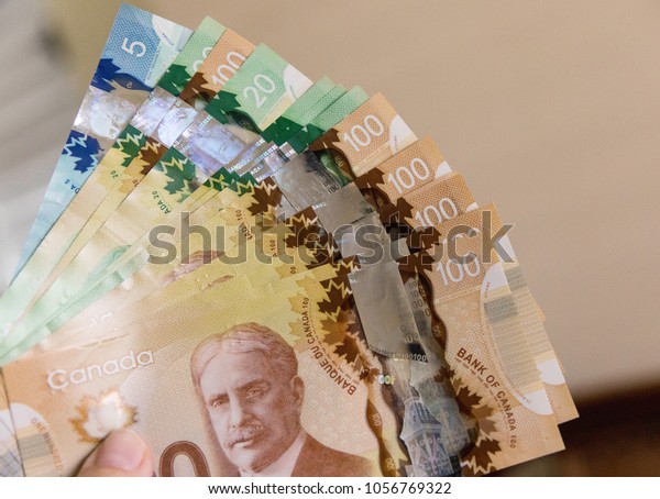 Canadian Dollars, concept of\
business and finance. Canadian banknotes of different values in\
hand.