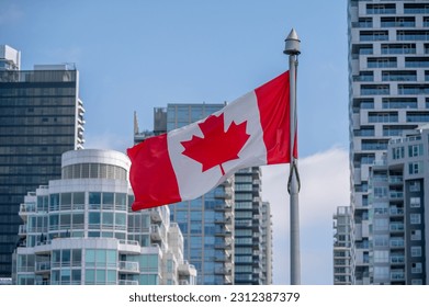 Canadian flag with downtown Vancouver in background.  Location is Granville Island. 