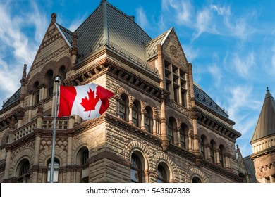 The Canadian flag flies before the Old City Hall in Toronto, Canada.