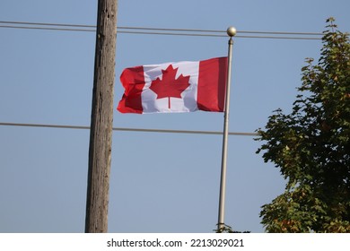 Canadian Flag Flying Between Hydro Lines