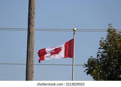 Canadian Flag Flying Between Hydro Lines