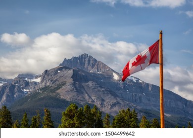 Canadian Flag with Rockie Mountains in the background during a sunny summer day. Taken in Banff National Park, Alberta, Canada.