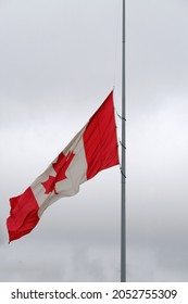 Canadian Flag Waving At Half Mast With Grey Cloudy Background. National Truth And Reconciliation Day