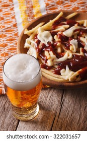 Canadian Food: Beer And Fries With Sauce Close-up On The Table. Vertical
