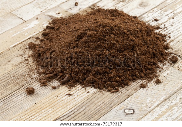 Canadian sphagnum peat
moss used as soil conditioner in gardening, a small pile on a
grunge wooden surface