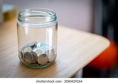 Canadian Toonie Loonie And Quarter Money In Jar On A Desk