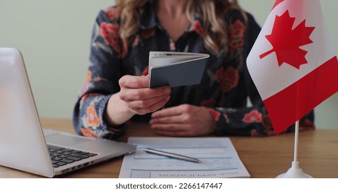 Canadian woman consular officer giving passport to male immigrant, work visa, citizenship. Visa Application online form immigration concept. Visa approval. - Shutterstock ID 2266147447