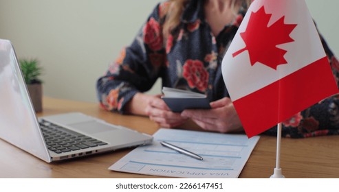 Canadian woman consular officer giving passport to male immigrant, work visa, citizenship. Visa Application online form immigration concept. Visa approval. - Shutterstock ID 2266147451