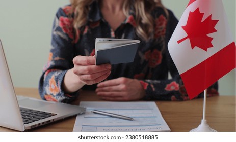 Canadian woman consular officer giving passport to male immigrant, work visa, citizenship. Visa Application online forms immigration concept. Visa approval. - Shutterstock ID 2380518885