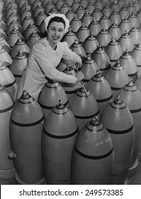 Canadian woman munitions worker tightening the nose plugs on 500-pound aerial bombs. 1942-43, during World War 2.