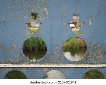 canal seen through holes and two arrows cut out in a metal plate
