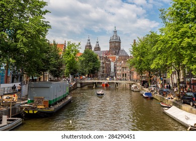 Canal And St. Nicolas Church In Amsterdam, Netherlands In A Summer Day