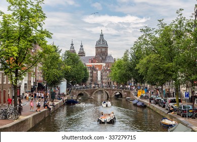 Canal And St. Nicolas Church In Amsterdam, Netherlands In A Summer Day