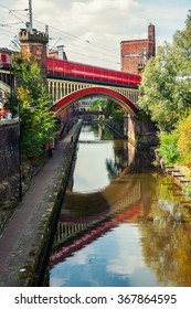 Canals Of Manchester, UK During The Day. Water Under The Red Bridge