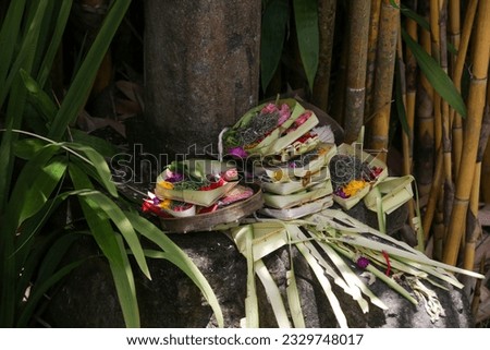 Canang sari, woven bamboo container with rice, flowers, incense, sweets and fruits. This is an offering to the Gods, as a gesture of gratitude in Bali, Indonesia.