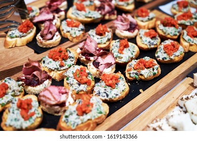 Canapes and appetizers on a table, close up. Catering service buffet tray with canapes and appetizing sandwiches - Shutterstock ID 1619143366