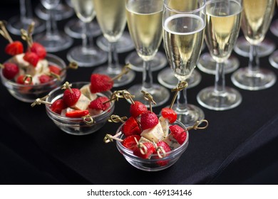 Canapes Of Cheese And Strawberries In Vases In The Background Are Glasses Of Champagne