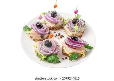 Canapes on toothpicks with herring fillet, olives and onion isolated on white background. Holiday banquet buffet snacks. Delicious appetizer