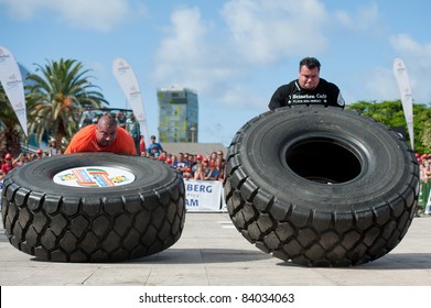 CANARY ISLANDS - SEPTEMBER 3: Ervin Katona (l) from Serbia and Arno Hams from Holland (r) lifting a wheel during Strongman Champions League in Las Palmas September 03, 2011 in Canary Islands, Spain