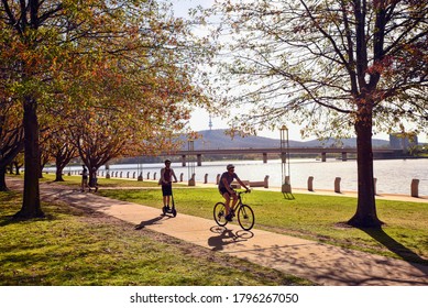 Canberra, ACT, Australia, 28 April 2020. During confinement period due to Covid 19, people exercise around the lake in Canberra. They enjoy a nice autumn day to cycle, walk or use an electric scooter.