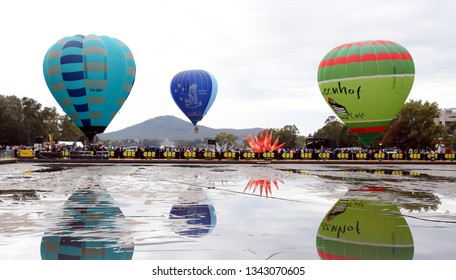 Canberra, Australia - March 9, 2019. Big hot air balloons taking off from the reflection ponds in front of Parliament house in Canberra, as part of the Balloon Spectacular Festival. 