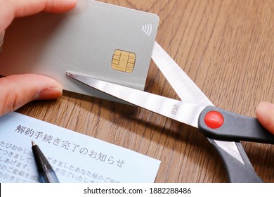 A Cancelled Credit Card Is Cut With Scissors. Documents In Japanese. Translation: Notice Of Completion Of Cancellation, Completed For Your Contract Offered, Thank You For Your Patronage So Far.