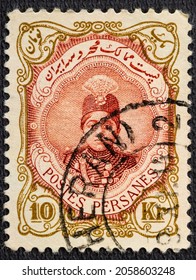 Cancelled postage stamp printed by Persia, that shows Ahmad Shah Qajar in an ornament frame, circa 1922.