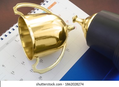 Cancelled Sport Event Concept. Broken Golden Trophy Cup On Calendar.