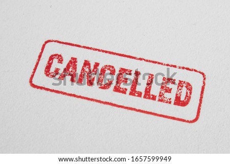 Cancelled stamp close up and isolated on white background. Cancelation message in red ink with border. Textured lettering on craft paper.