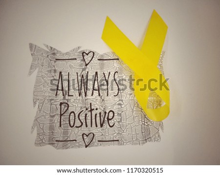 cancer awareness ribbon with 'Always positive' word on white background.