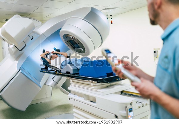 Cancer\
treatment in a modern medical private clinic or hospital with a\
linear accelerator. Professional doctors team working while the\
woman is undergoing radiation therapy for\
cancer