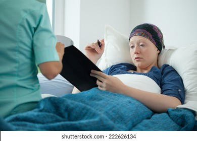 Cancer Young Woman Signing Documents In Hospital