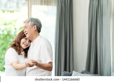 Candid Of Attractive Senior Asian Couple Dance Together At Home In Dance Exercise Activity Class For Older Adult With Copy Space. Mature Asian Happy Man And Woman In Lifestyle Of Retirement Concept.