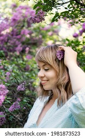 Candid Authentic Portrait Of 30s 40s Caucasian Blonde Woman With Lilac Flowers. 30 40 Year Old Woman Enjoying Life In Lilac Flowers Nature Background. Reinvention, Life Changes, Reinvent Yourself