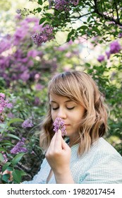 Candid Authentic Portrait Of 30s 40s Caucasian Blonde Woman With Lilac Flowers. 30 40 Year Old Woman Enjoying Life In Lilac Flowers Nature Background. Reinvention, Life Changes, Reinvent Yourself